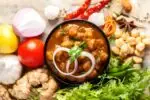 Authentic Punjabi Chole served with chopped onions, lemon wedge, and coriander garnish.