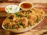 Homemade vegetable biryani served in a traditional copper handi with fresh herbs and saffron rice
